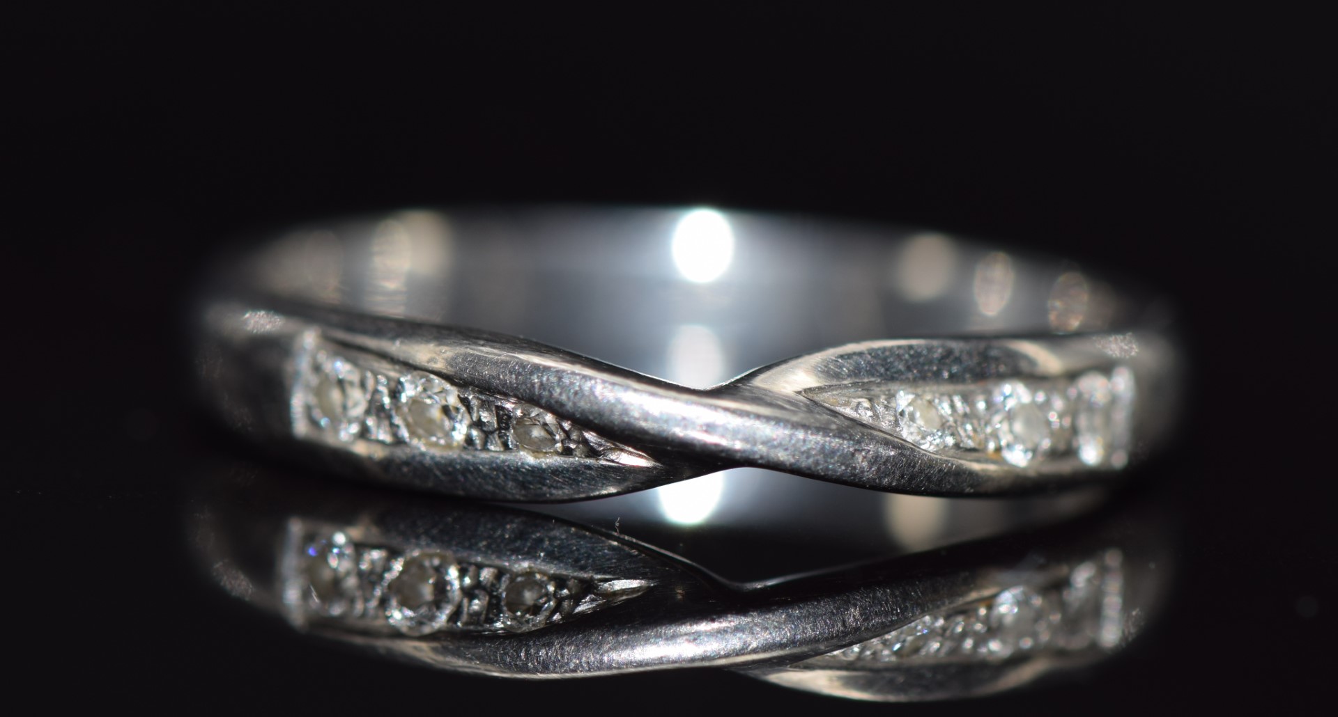 A platinum wedding band / ring with twisted design to fit engagement ring set with six round