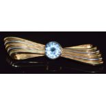 A 14k gold bi-coloured brooch in the form of a stylised bow set with topaz, 12.8g