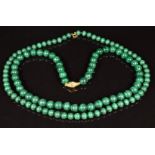 Two malachite beaded necklaces, one with 9ct gold clasp, the other 18ct