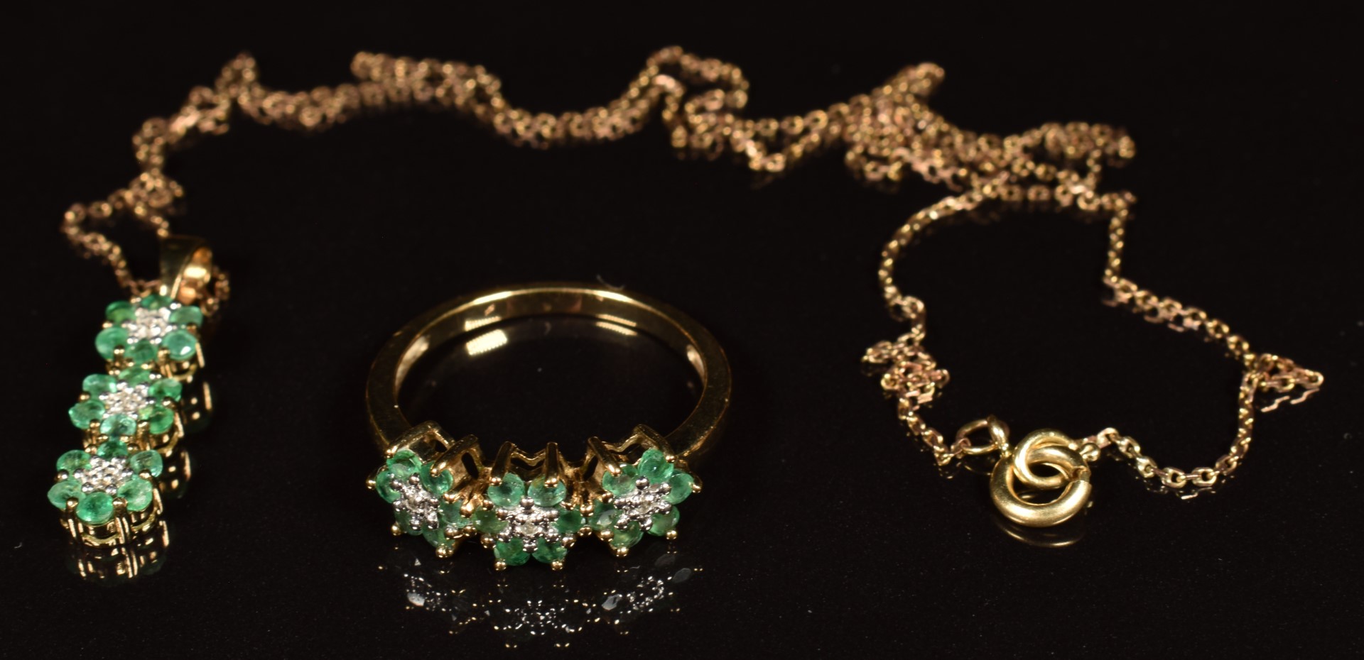 A 9ct gold ring set with diamonds and emeralds in three floral clusters, with matching pendant and