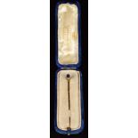 A 9ct gold stick pin set with an oval sapphire (1.4g), in antique box