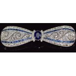 A c1915 platinum brooch in the form of a bow set with an oval cut sapphire measuring approximately