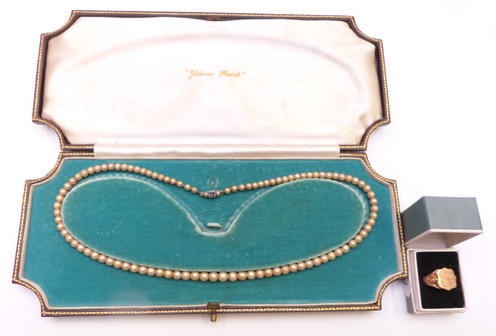 A strand of faux pearls with a 15ct gold clasp set with a sapphire and seed pearls and a section