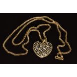 A 14k gold pendant in the form of a heart with pierced floral decoration, on a 9ct gold chain, 12g