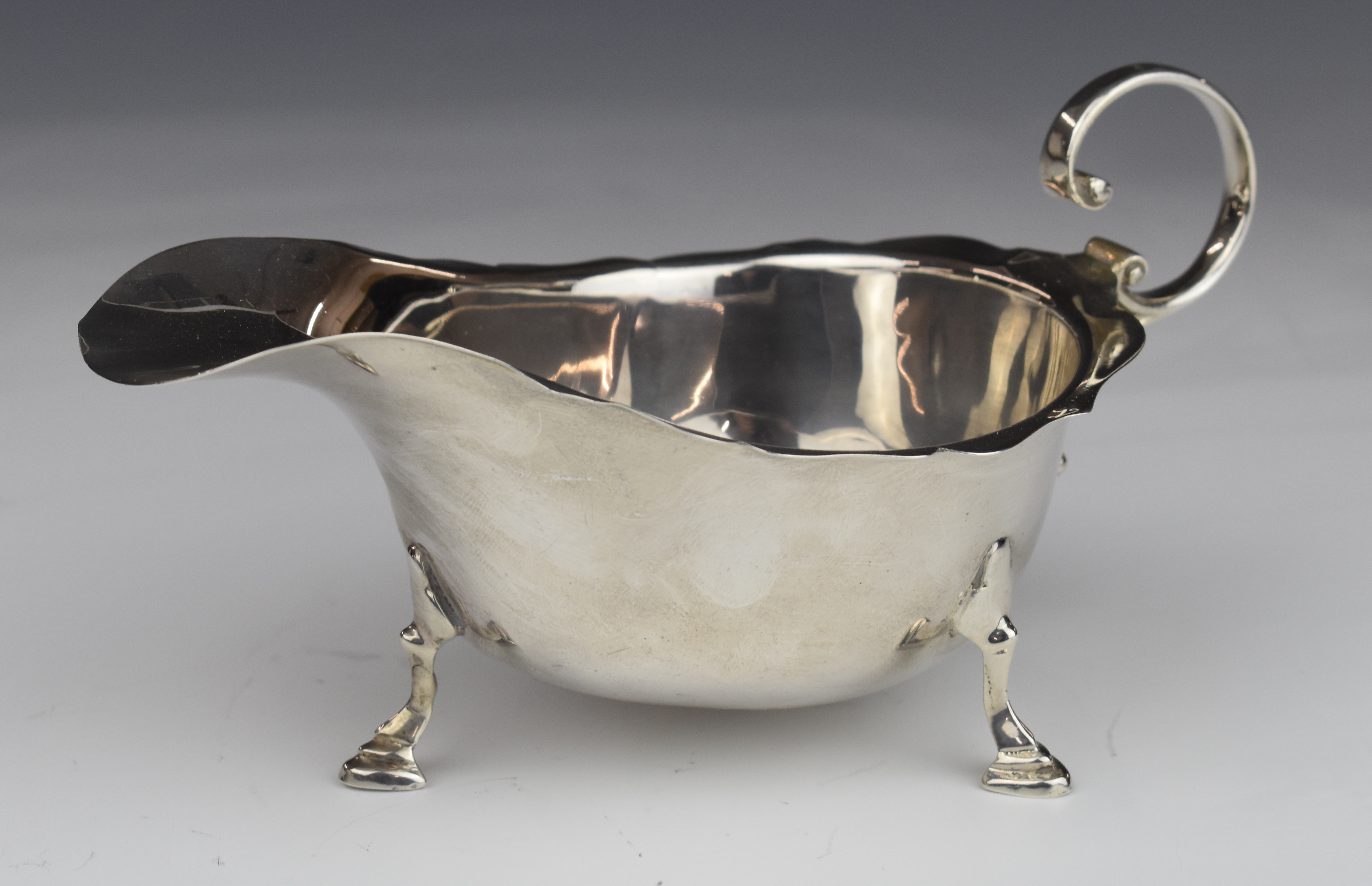 Asprey George VI hallmarked silver sauce boat raised on three feet, London 1938, length 15.5cm,