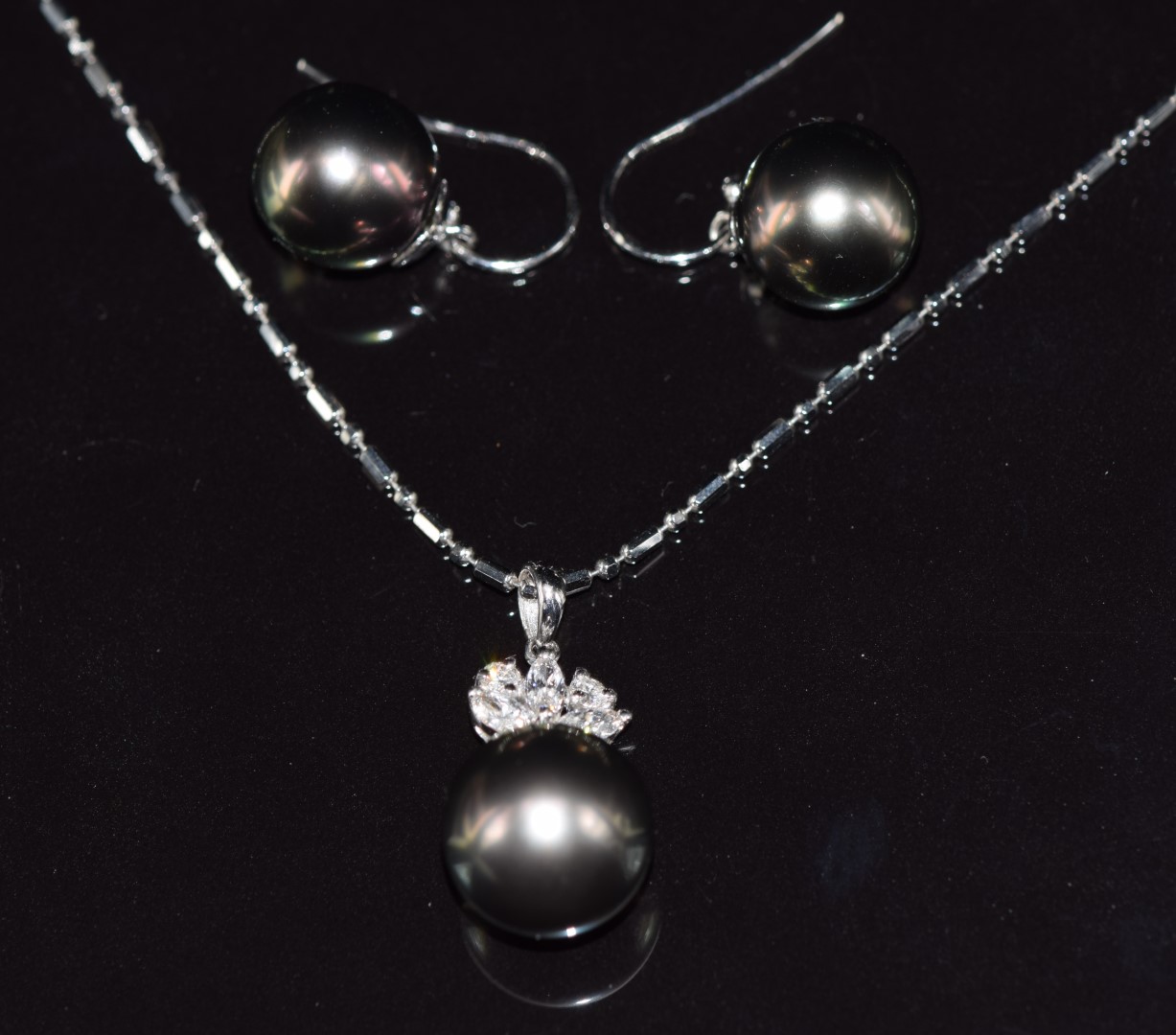 An 18ct white gold pendant set with a 13ct black South Sea pearl, three marquise cut diamonds and