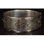 A hallmarked silver bangle with applied gold leaf decoration (waxed filled)