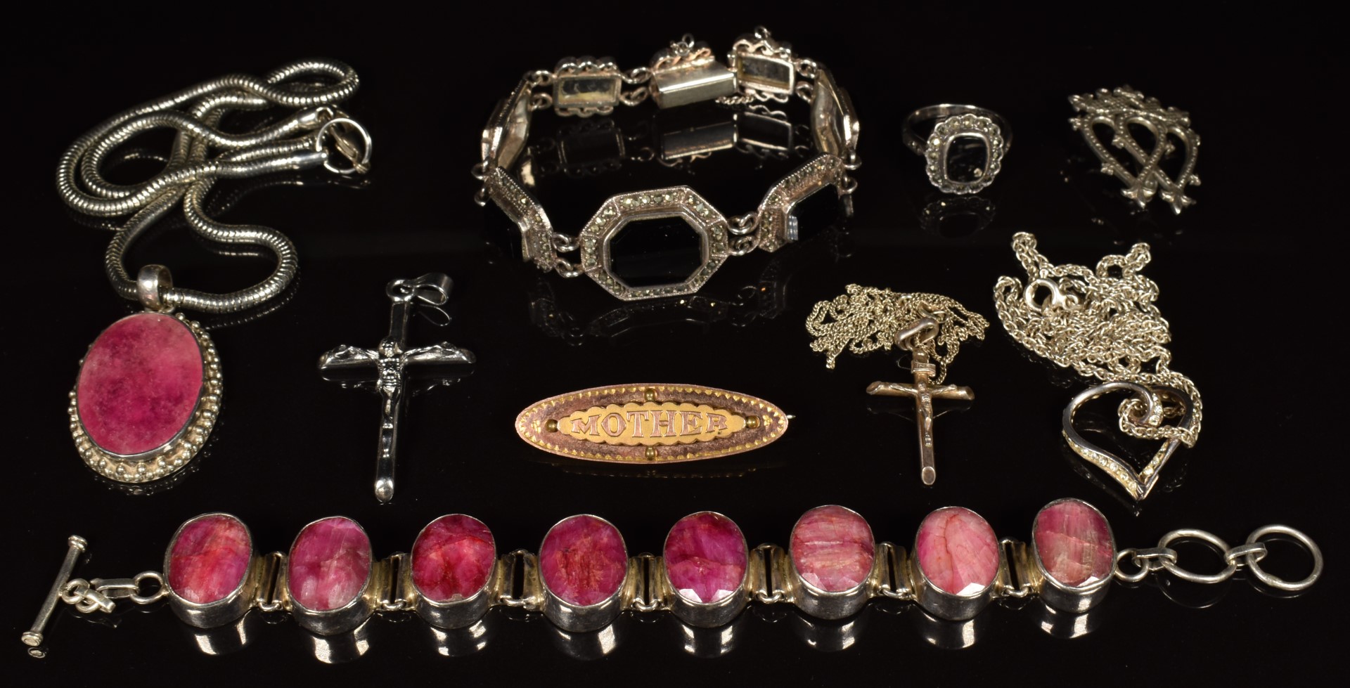 A silver bracelet set with rubies, a silver bracelet set with onyx, silver pendants and chains,