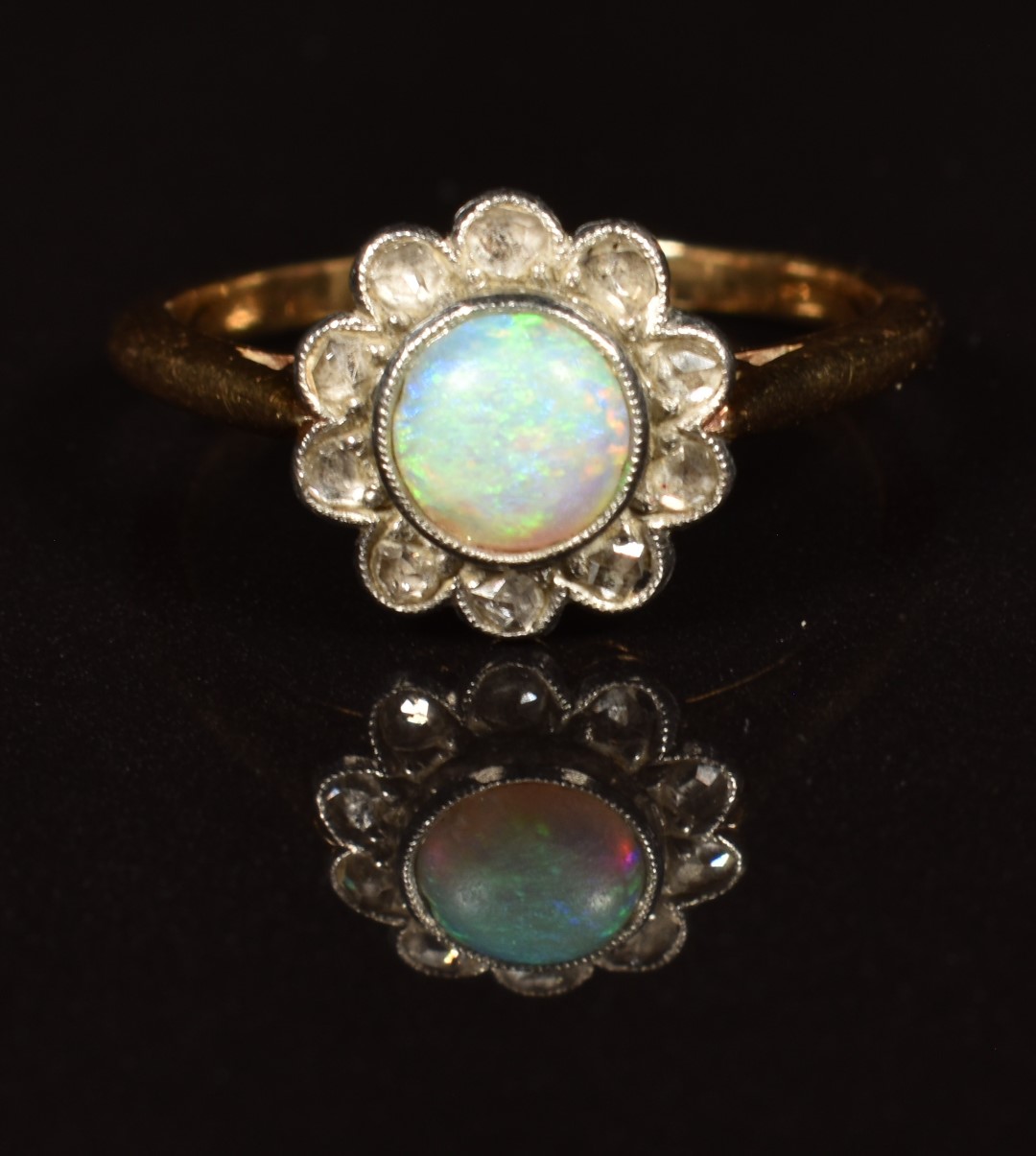 An 18ct gold ring set with an opal surrounded by rose cut diamonds, in vintage box, 2.9g, size M