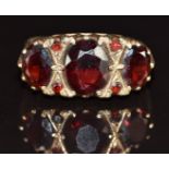 A 9ct gold ring set with three large oval cut garnets and four round cut garnets, 4.5g, size O/P