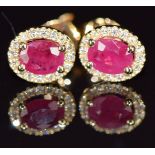A pair of 18ct gold earrings each set with a 0.5ct ruby surrounded by diamonds, 1.6g