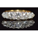 An 18ct gold ring set with five old cut diamonds and eight rose cut diamonds, the centre diamond