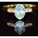 An 18ct gold ring set with an oval cut aquamarine and diamonds, 2.3g, size J