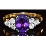 An 18ct gold ring set with an oval cut amethyst and six old cut diamonds in a platinum setting, 4.