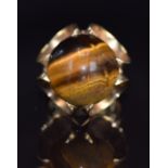 A 9ct gold ring set with a tiger's eye cabochon, London 1972, 10g, size J