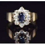 A 9ct gold ring set with a sapphire surrounded by diamonds, 2.8g, size J