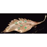 A 14k gold brooch in the form of a leaf set with emeralds, 8g