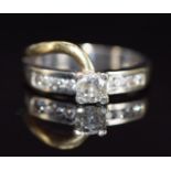 An 18ct gold bi-coloured ring set with a round cut diamond of approximately 0.4ct, with further