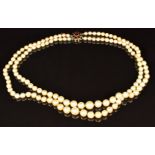 A double strand of cultured pearls, the 9ct gold clasp set with garnets