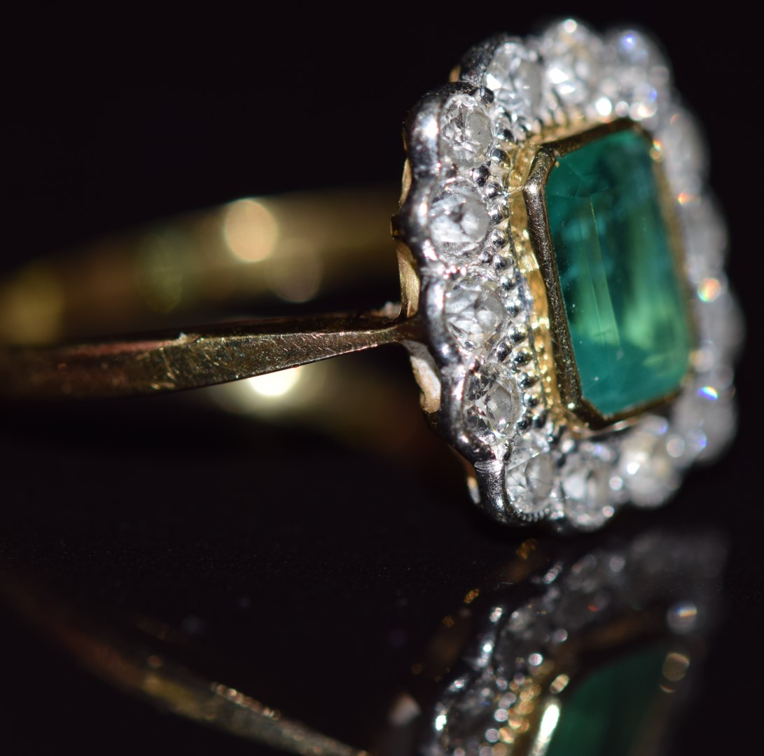 An 18ct gold ring set with an emerald cut emerald measuring approximately 1ct surrounded by 14 - Image 2 of 2