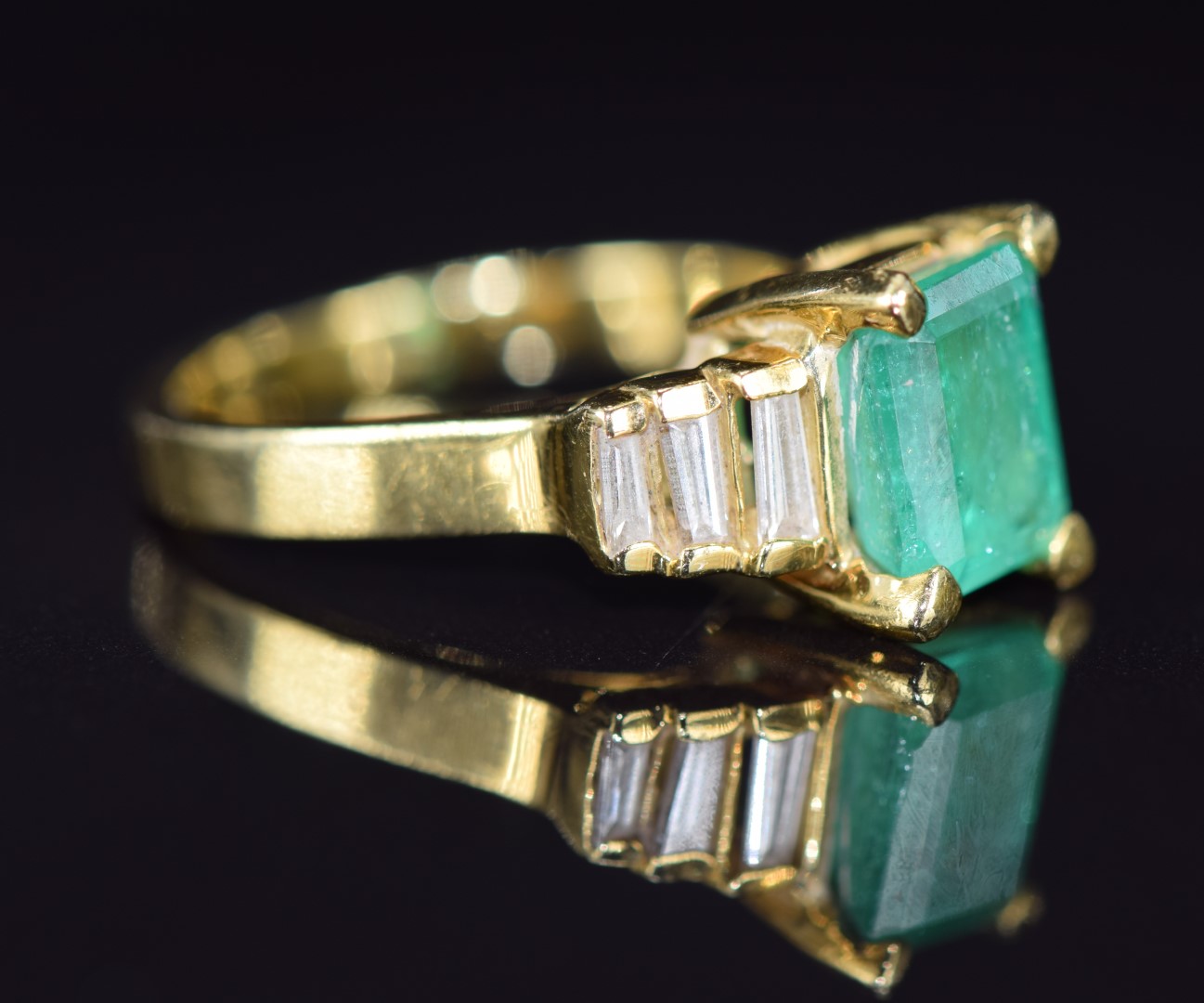 An 18k gold ring set with an emerald cut emerald of approximately 1.9ct and six baguette cut - Image 2 of 2