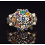 An 18K gold ring set with sapphires, garnet, tiger's eye, citrine, topaz etc in a domed cluster, 4.