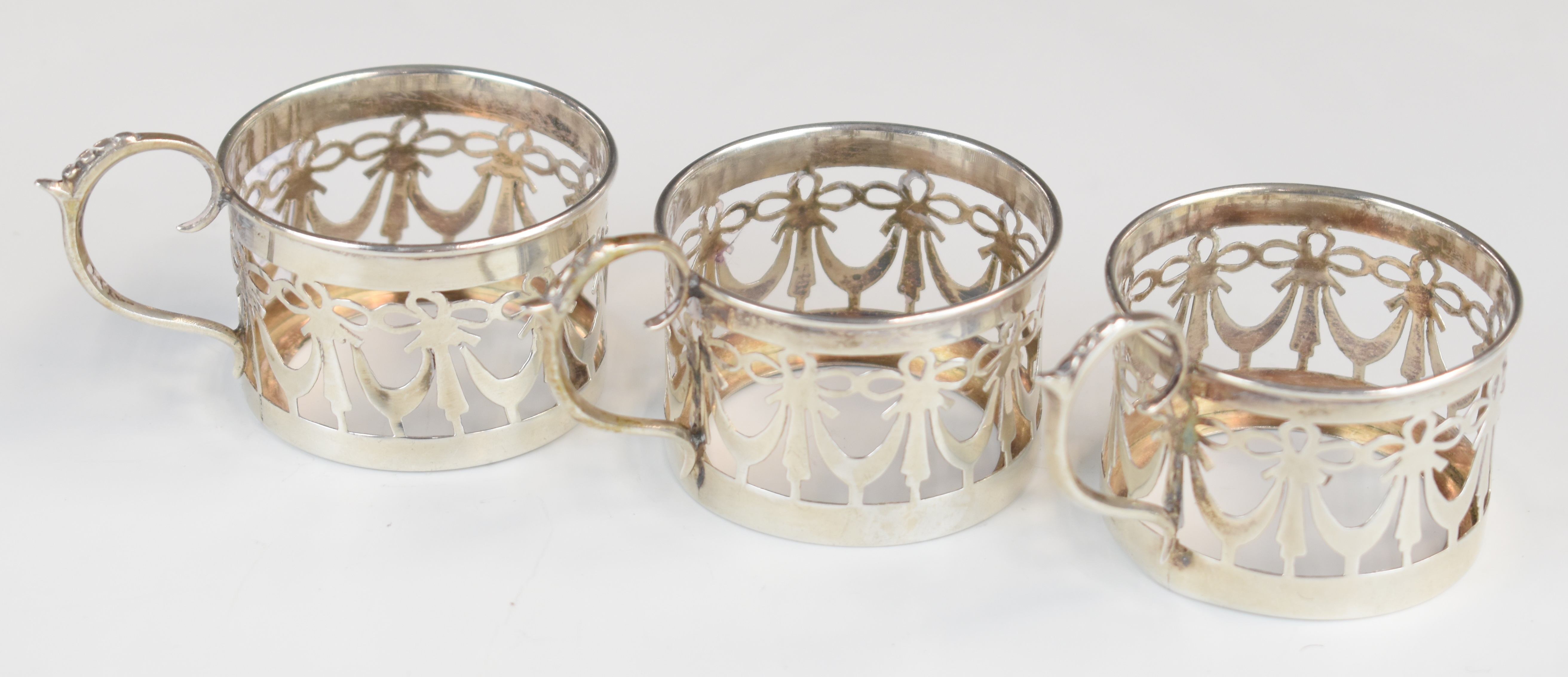 Set of three George V hallmarked silver cup or glass holders with pierced decoration, Birmingham