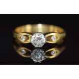 An 18ct gold ring set with a round cut diamond of approximately 0.5ct and two smaller diamonds to
