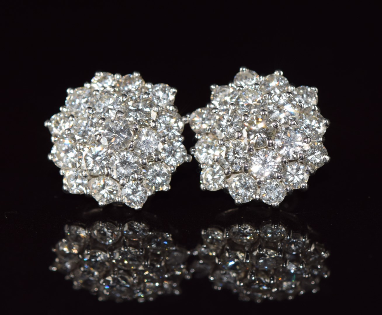 A pair of 18ct white gold earrings each set with nineteen round cut diamonds, each approximately 0.