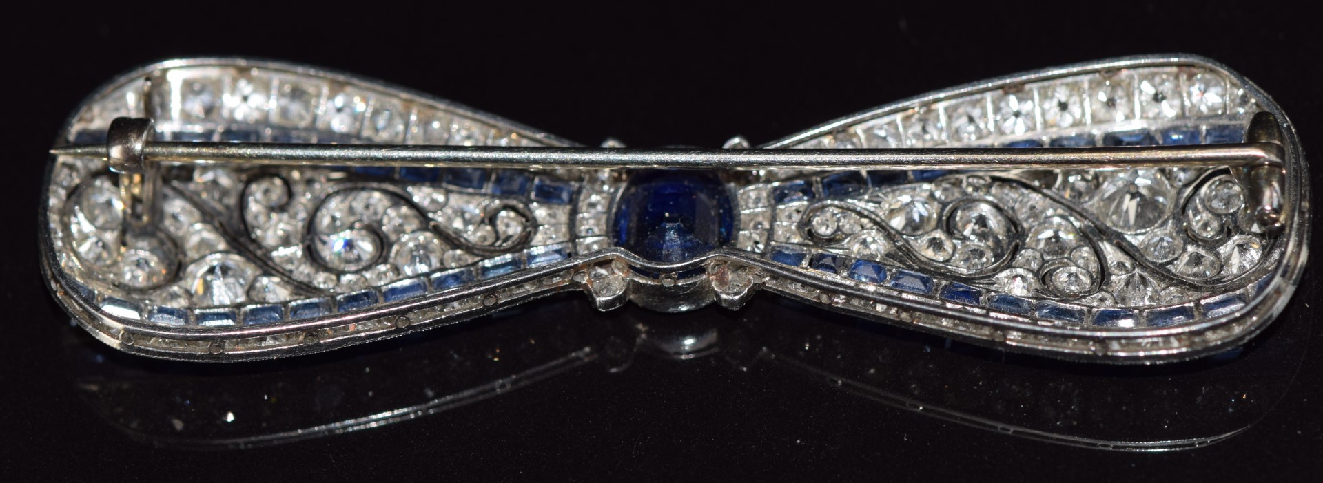 A c1915 platinum brooch in the form of a bow set with an oval cut sapphire measuring approximately - Image 4 of 7