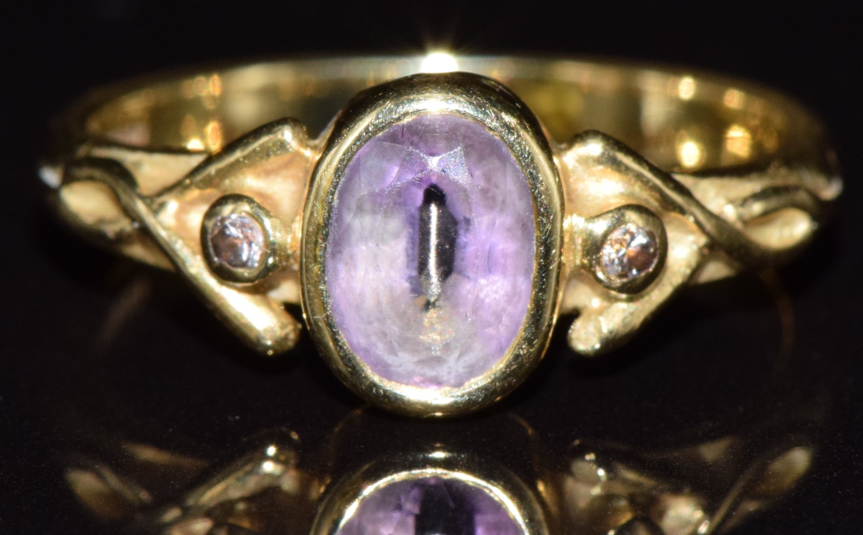 An 18ct gold ring set with an oval cut amethyst and two diamonds, 3.5g, size L - see lot 691 for