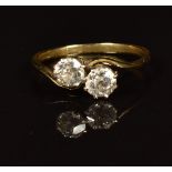 An 18ct gold ring set with two old cut diamonds each approximately 0.3ct, in a twist setting, in