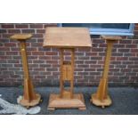 An oak church lectern, 117cm high; together with two similar oak adjustable stands.