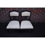 A pair of late Victorian ebonized salon occasional chairs.