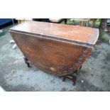 An antique carved oak gateleg table, 122cm wide.