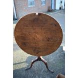 A George III mahogany circular tilt top tripod table, 86cm wide; together with a tapestry top stool.
