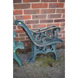 A pair of green painted cast iron bench ends.