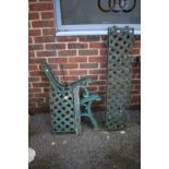 A pair of green painted cast iron bench ends.