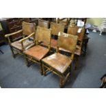 A set of six 17th century style oak and studded leather dining chairs, to include an elbow chair.