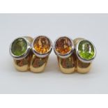 (NB) A pair of circa 1960s ear clips, set oval peridots and amber coloured citrines, by Ernst