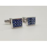 (NB) A pair of rectangular cufflinks, each head set with twelve French cut square sapphires, stamped