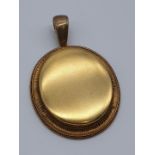 (NB) A Victorian yellow metal oval locket, stamped 585, 48 x 43mm, gross weight 35g.