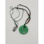 (NB) A jadeite double disk pendant, 45mm diameter, on original silk cord.