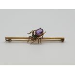 (NB) A late Victorian yellow metal spider bar brooch with amethyst and emerald set body, 56mm.