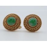 (NB) A pair of yellow metal cufflinks, each set with a cabochon jade to centre with a triple rope