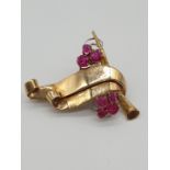 (NB) A yellow metal ruby scroll clip, stamped 9ct, by Alabaster & Wilson, 38 x 37mm, gross weight