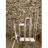A graduated set of three metal plant stands, largest 150cm high, smallest 90cm high.