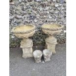 A pair of reconstituted stone bird baths; together with two similar smaller urns.