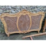 A carved giltwood and cane double bed, 152cm wide x 149cm high.