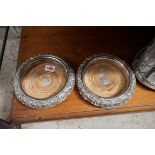 A pair of Old Sheffield plate bottle coasters, with fruiting vine decoration, 19cm diameter, (